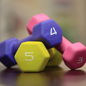 A set of three colorful dumbells, at 3, 4 and 5 pounds.